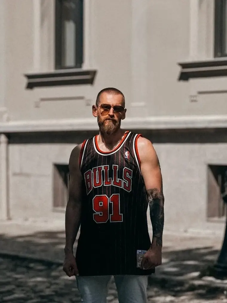 Illusional V in aviator sunglasses and a Chicago Bulls jersey on a cobblestone street